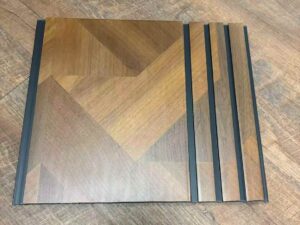 Brown geometric wood-finish fluted wall panel with dark grey vertical grooves and a modern angular pattern.