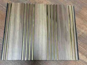 Grey wood-texture fluted wall panel with multiple vertical grooves and decorative gold metallic strips.