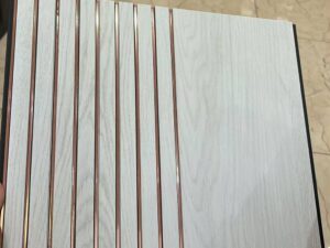 White marble finish fluted wall panel with rose gold vertical lines