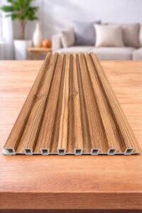 Wood finish fluted wall panel with a natural brown wood-grain texture displayed on a wooden surface.