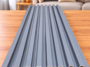 Grey fluted wall panel with vertical grooves displayed on a wooden table